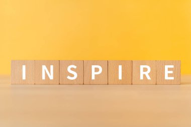 Wooden blocks with INSPIRE text of concept.