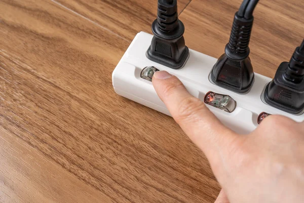 Power strip and a human hand.