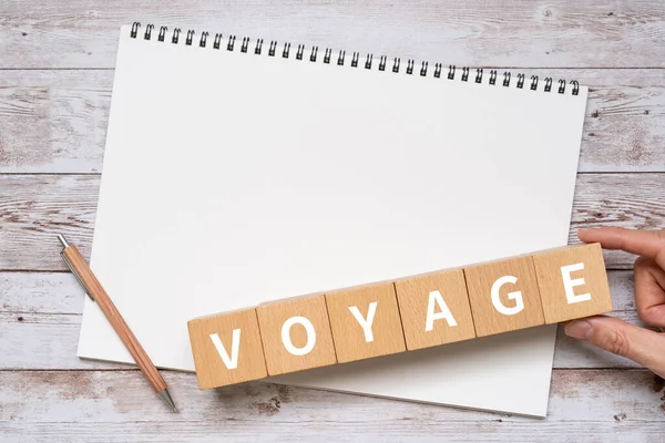 带有Voyage概念 笔记本和手的木块 — 图库照片