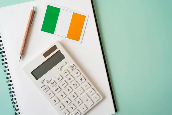 爱尔兰国旗 计算器 钢笔和笔记本放在桌上 — 图库照片