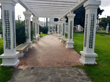 Riad Al Amel Tetouan, Fas. Yeşilliklerin arasına kurulmuş serin banklarda dinlenin. Mağribi sütunları bir muhafız gibi duruyor, Tetouan Fas 'ın göbeğindeki sakin bir vaha üzerine uzun gölgeler döküyorlar..