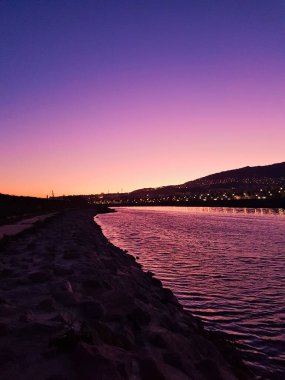 Parlak renkler, güneş kaybolduktan sonra şehrin dibindeki nehre yansıyor.