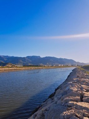 Wadi Martil ve arka planda Jbel Bouanane. Dağ zarifçe yükselir, engebeli yamaçları yemyeşil renklerle süslenir. Sessiz bir vadide, manzaraya bir dokunuş katıyor..