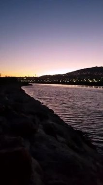 Su akmaya devam ettikçe, güneş kaybolduktan sonra şehrin altındaki vadiye canlı renkler yansıyor.