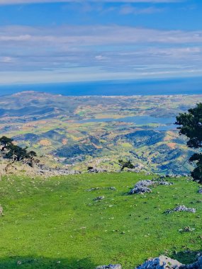 Splendor of nature from the top of Fahs lmhar in Tetouan, Morocco. Landscapes of the top are a magic beauty of their circulating hills, lakes with vibrant plants that paint the scene below clipart