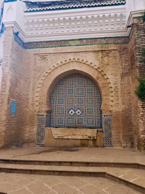 Kiremitlerle dekoratif sütunlar geleneksel işçiliğin ve kamu bahçesinde mozaiklerin karmaşık tasarımının büyüleyici bir karışımı.