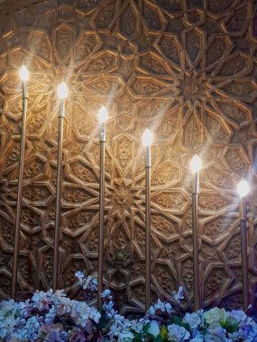 Işıklar, özenle oyulmuş ahşap ve zarif çiçeklere karşı titizlikle düzenlenmiştir. İnce işçilikle aydınlatmayı mükemmel bir şekilde birleştiren büyüleyici bir sahne yaratırlar..