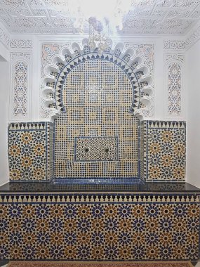 Fas zellige karoları, ayrıntılı alçı işçiliğiyle çerçevelenmiş, zengin, ayrıntılı desenleri ortaya çıkarıyor. Karmaşık motifleri Fas sanatının mirasını ve zanaatkarlığını merkezinde avizeyle kutluyor..