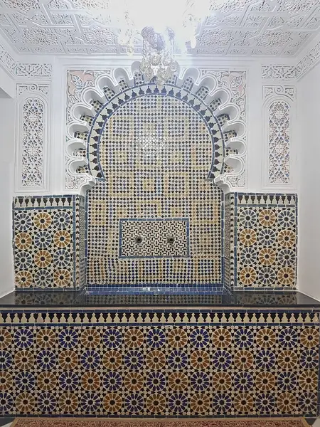 Fas zellige karoları, ayrıntılı alçı işçiliğiyle çerçevelenmiş, zengin, ayrıntılı desenleri ortaya çıkarıyor. Karmaşık motifleri Fas sanatının mirasını ve zanaatkarlığını merkezinde avizeyle kutluyor..