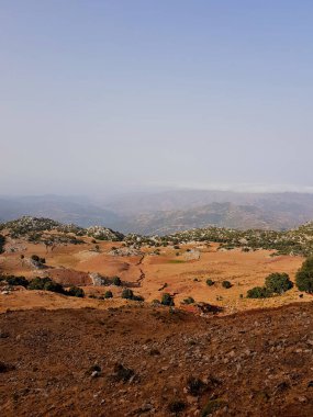 Zirveden manzara: aşağıdan, güneşli vadiler, yuvarlanan tepeler ve yamaçlar engin, sakin bir dağ manzarası boyunca uzanan uzak ovalara bir sonbahar akşamı altın saatinde