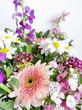 Bir buket çiçek. Japon dianthus, gerbera, matthiola, papatya ve defne yaprakları. çiçek kompozisyonu. bahar kartpostalı. Gündüz fotoğrafçılık.