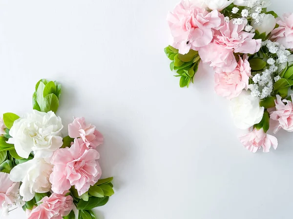 Border frame made of pink and white carnations flower on white background. Flat lay, top view. Flowers frame.