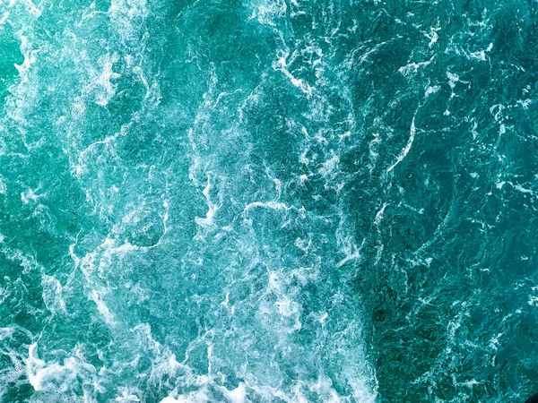 Su yüzeyinin arka plan görüntüsü. Mavi deniz ve dalgalar. Kartpostallar, harfler ve bulmacalar için ideal.