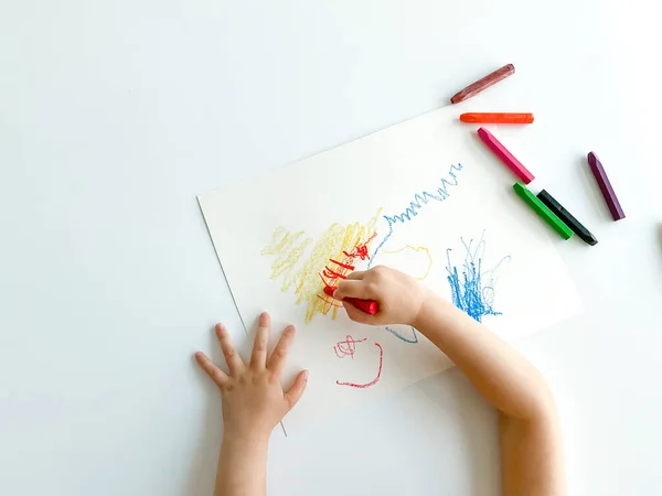 Küçük çocuk beyaz masaya pastel boya kalemleriyle resim çiziyor. Babalar günü. Yüksek kalite fotoğraf