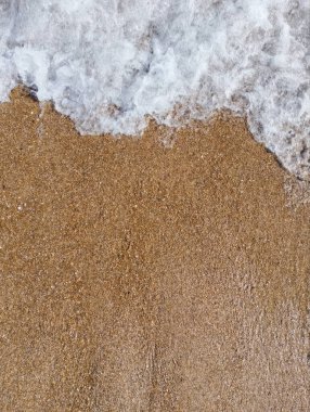 Kumsalda kumlar ve dalgalar, yakın çekim. Yukarıdan bak. Yüksek kalite fotoğraf