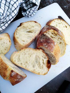 Beyaz bir kesme tahtasında dilimlenmiş ciabatta ekmeği. Yüksek kalite fotoğraf 