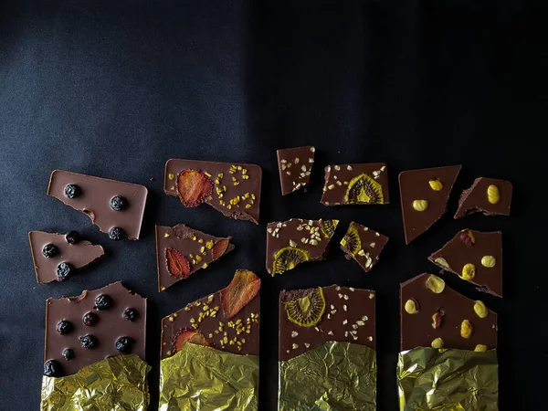 Çikolata parçaları. Böğürtlen, çilek, kivi ve altın folyoyla. Yüksek kalite fotoğraf