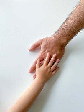Yetişkin ve çocuk el ele tutuşur. Babalar Günü. Bir çocuk bir yetişkine yardım eder. Kartpostal konsepti