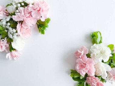 Beyaz arka planda pembe ve beyaz karanfillerden yapılmış sınır çerçevesi. Düz yerde, üst tarafta. Çiçek çerçevesi.