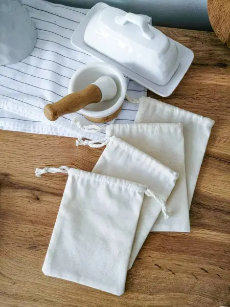 Tahta bir masada beyaz pamuk torbaları ve çatal bıçaklar. Kumaş çanta modeli. Yüksek kalite fotoğraf