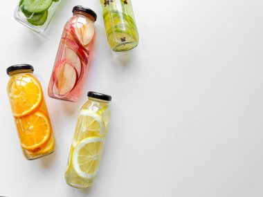 Beyaz arka planda cam şişelerde çeşitli detoks içecekleri, fotokopi alanı ile birlikte. Tasarım ve baskı için sağlıklı yaşam tarzı ve hidrasyon kavramı. Yüksek kalite fotoğraf