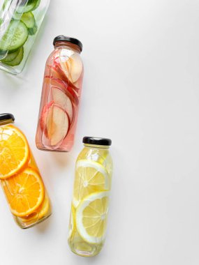 Beyaz arka planda cam şişelerde çeşitli detoks içecekleri, fotokopi alanı ile birlikte. Tasarım ve baskı için sağlıklı yaşam tarzı ve hidrasyon kavramı. Yüksek kalite fotoğraf