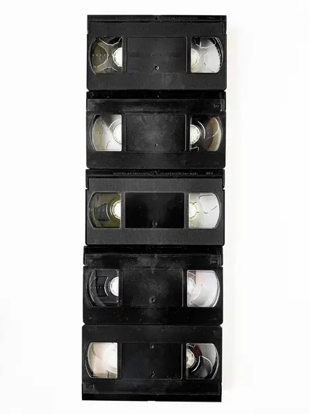 stock image Vintage vhs cassettes stacked vertically on white background.