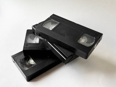 Nostaljik teknolojiyi yansıtan beyaz arkaplandaki Retro vhs kasetleri.