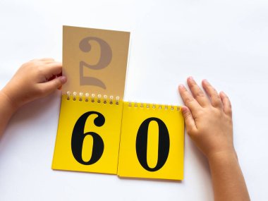 Childs 'ın elleri sarı sayfaları numaralarla çeviriyor. Beyaz arkaplanda 60 numarayı göster.