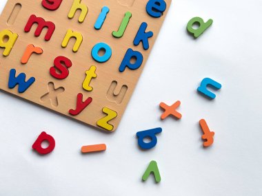 Erken eğitim ve eğlenceli öğrenme için renkli ahşap alfabe yapboz tahtası.