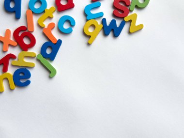 Eğitim ve öğrenim kavramları için beyaz arka plana dağılmış renkli alfabe harfleri.