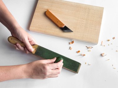 Kesme tahtası ve oyma bıçağının yanında sürgü ile elleri keskinleştirme aracı.