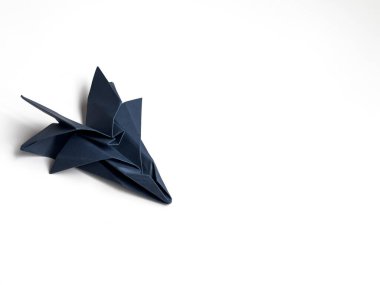 Minimalist beyaz arka planda zarif koyu mavi origami leyleği.