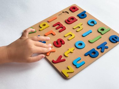 Beyaz arkaplanda renkli alfabe bulmacası ile çocuk öğrenme.
