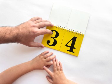 Baba ve çocuk takvimin sayfasını büyük sayılarla çevirdiler..