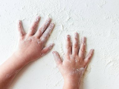 Beyaz yüzeyde un kaplı Childs elleri.