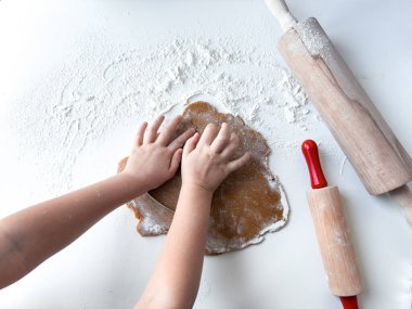 Childs 'ın elleri hamuru iki tahta oklavayla yuvarlıyor..