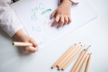 Beyaz kağıda renkli kalemlerle çocuk çizimi.