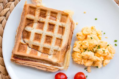 Yumurtalı tost ve beyaz tabakta vişneli domates..
