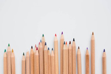 Sanat ve tasarım ilhamı için arka planda ışık sırasına dizilmiş renkli tahta kalemler.