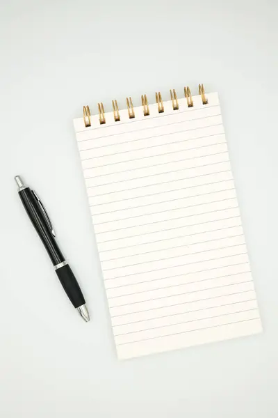 Yazmak ya da notlar için beyaz zemin üzerine sarmal defter ve kalem.