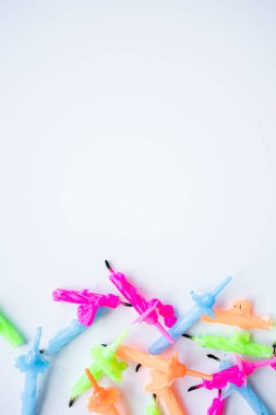 Beyaz arkaplanda düzenlenmiş renkli doğum günü mumları.