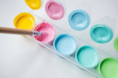 Fırçalı renkli boya paleti. Sanatsal yaratıcılık için sarı, pembe, açık mavi, su renkleri.