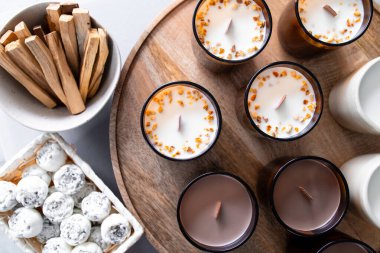 Aromaterapi mumları, şakayık ve palo santo şeklinde ahşap tepside sergilenen katı aroma yağı..