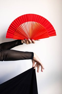 Kırmızı Asyalı yelpazenin zarif gösterisi siyah elbiseli ve kolları düz kadınların ellerinde..