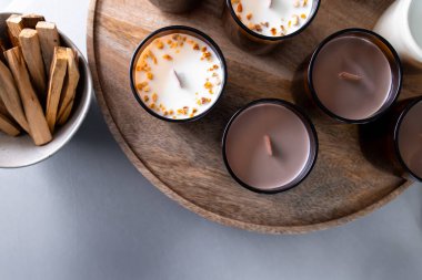 Aromatik kokulu mumlar ve yuvarlak tepside ahşap filizler..