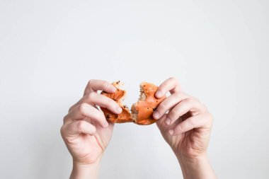 Eller beyaz arka planda simit kırıyor..