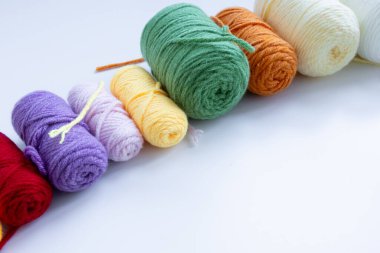 Çeşitli gölgelerde beyaz arkaplanda renkli iplik topları.