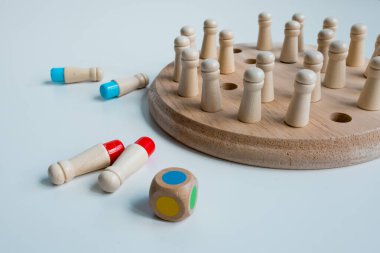 Tahta tahta masa oyunu, beyaz yüzeyde çiviler ve renkli zarlar.