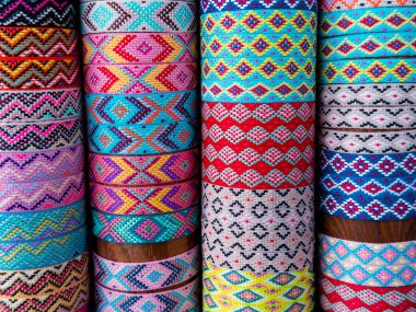 Geleneksel geometrik tasarımlı renkli tekstil ruloları.